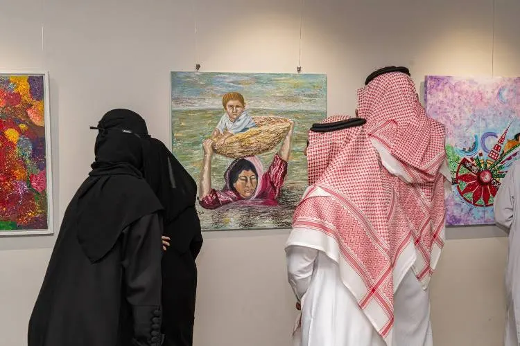 بقصتها المؤلمة.. أم عراقية تستوقف زوار معرض فني بالقطيف