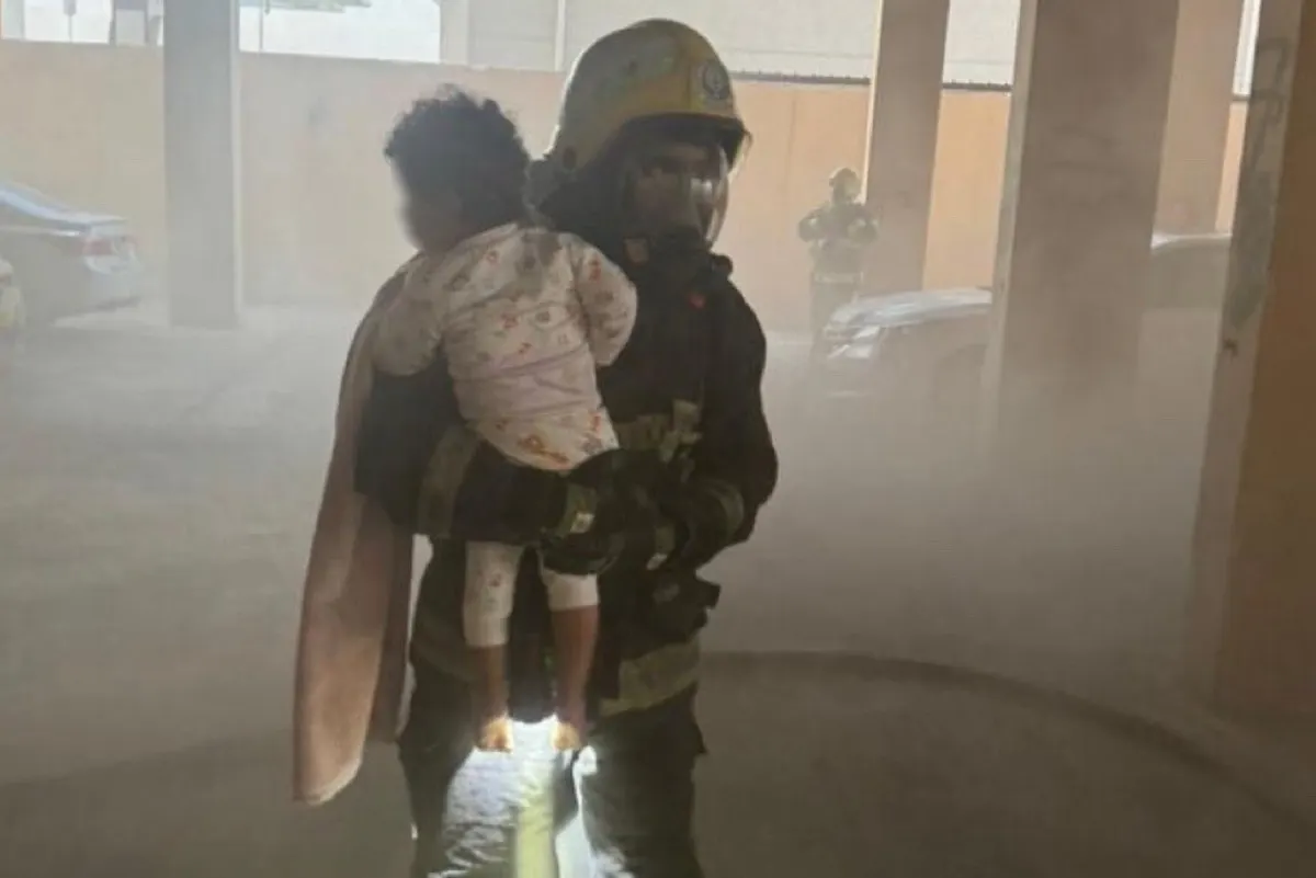 طفل في حضن رجل الإطفاء.. إخماد حريق داخل مبنى بالدمام