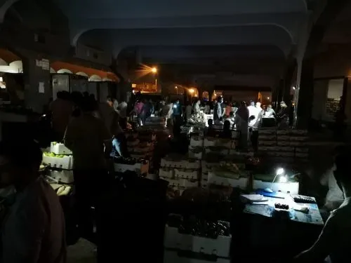 الصور تتحدث: خضّارو سوق الدمام يبيعون بضاعتهم تحت ضوء الجوالات