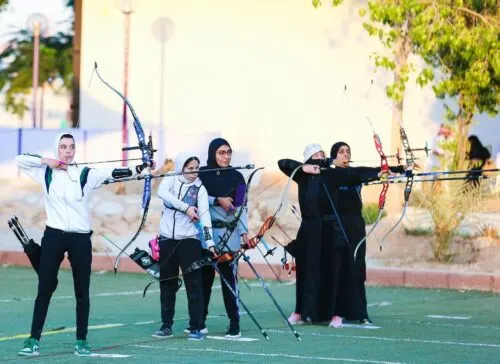 فتيات وشبان يجربون رمي السهام في العوامية